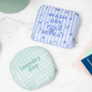 Image of Miamica's Clubhouse Days laundry bags. A green plaid circular laundry bag says "laundry day. " A Periwinkle square laundry bag says "Wash Dry Fold Repeat."
